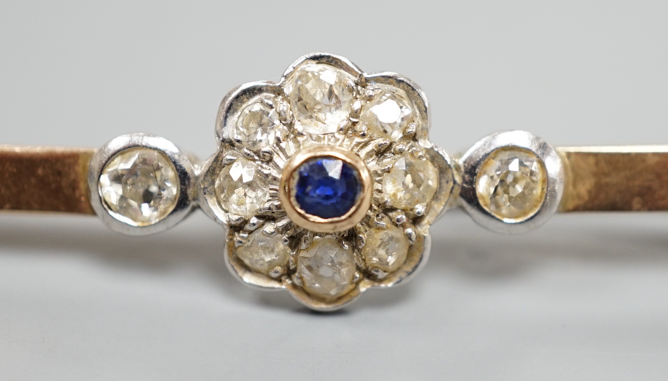 A 9ct, sapphire and diamond cluster set bar brooch (possibly converted), 65mm, gross weight 5.7 grams.